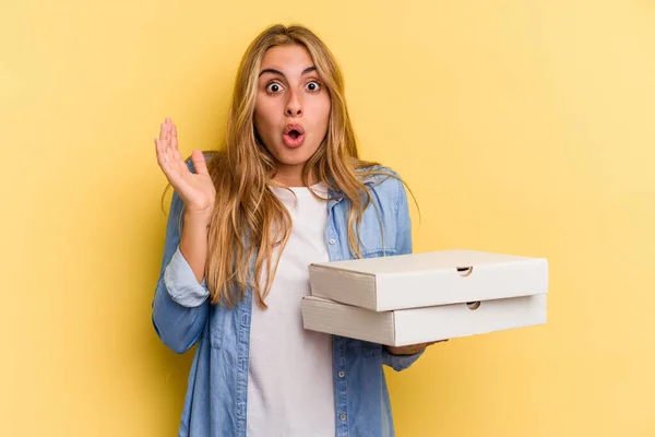 Jonge Kaukasische Blonde Vrouw Met Pizza Geïsoleerd Gele Achtergrond Verrast — Stockfoto