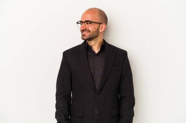 Genç ve kel bir adam beyaz arka planda izole edilmiş gülümsüyor, neşeli ve keyifli görünüyor..