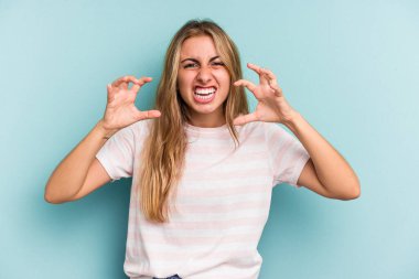 Mavi arka planda izole edilmiş beyaz, sarışın bir kadın öfkeyle bağırıyor..