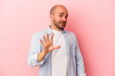 Beyaz saçlı genç adam pembe arka planda izole edildi. Yakın bir tehlike nedeniyle şok oldu.