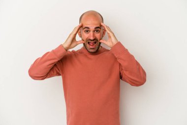 Genç kel adam beyaz arka planda izole edilmiş. Hoş bir sürpriz bekliyor. Heyecanlı ve el kaldırıyor..
