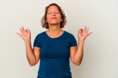 Beyaz arka planda izole edilmiş orta yaşlı Latin kadın yoğun bir günün ardından rahatlıyor, yoga yapıyor..