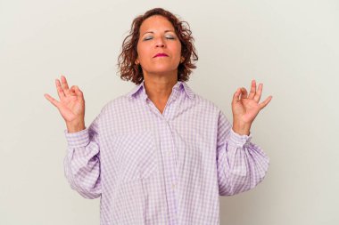 Beyaz arka planda izole edilmiş orta yaşlı Latin kadın yoğun bir günün ardından rahatlıyor, yoga yapıyor..