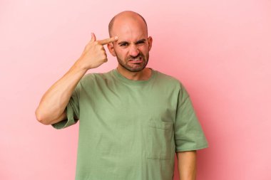 Pembe arka planda izole genç beyaz kel adam işaret parmağıyla hayal kırıklığı jesti gösteriyor..