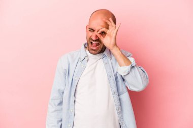 Genç, beyaz, kel bir adam pembe arka planda izole edilmiş. Heyecanlı..
