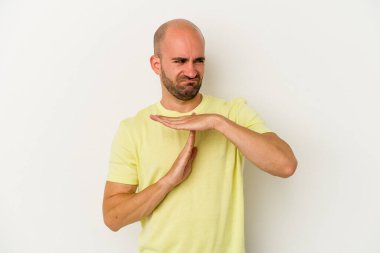 Beyaz arka planda izole edilmiş genç kel bir adam bir mola hareketi gösteriyor..