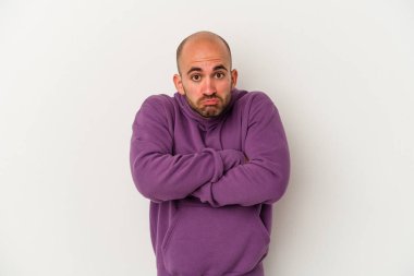 Beyaz arka planda izole olmuş genç kel adam omuz silkiyor ve gözleri açık..