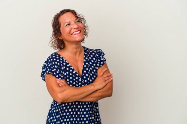 Beyaz arka planda izole edilmiş orta yaşlı Latin bir kadın. Kollarını kavuşturup gülümsüyor..