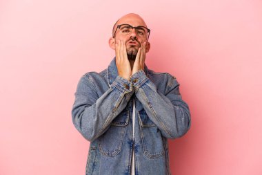 Kafkasyalı kel bir adam pembe arka planda izole edilmiş sızlanıyor ve ağlıyordu..