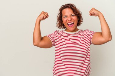 Beyaz arka planda izole edilmiş orta yaşlı Latin bir kadın zaferden sonra yumruğunu kaldırıyor, kazanan konsept.
