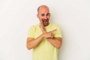 Genç kel adam beyaz arka planda izole edilmiş. Dedikodu yapıyor, bir şeyleri bildiriyor..