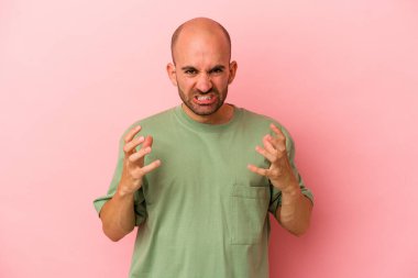 Pembe arka planda izole edilmiş beyaz kel bir adam öfkeyle bağırıyor..