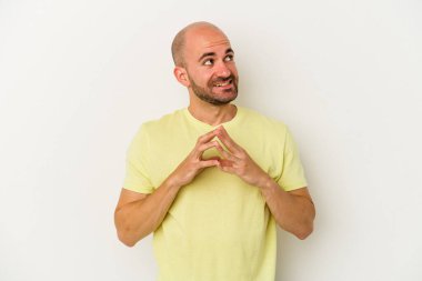 Genç, kel bir adam beyaz arka planda izole edilmiş. Kafasında bir plan kuruyor..