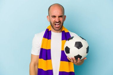 Mavi arka planda izole edilmiş atkı takan genç ve kel bir adam çok sinirli ve agresif bağırıyor..