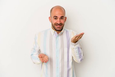 Beyaz arka planda soyutlanmış genç kel adam kollarıyla ölçek oluşturuyor, mutlu ve kendinden emin hissediyor..