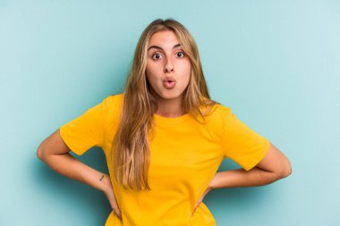 Mavi arka planda izole edilmiş beyaz bir kadın gördüğü bir şey yüzünden şoka uğruyor..