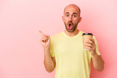 Kafkasyalı genç kel adam elinde kahve tutuyor. Pembe arka planda izole edilmiş. Yan tarafı gösteriyor.