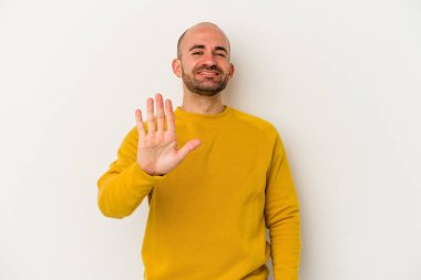 Genç kel adam beyaz arka planda izole edilmiş. Gülümsüyor beş numarayı parmaklarıyla gösteriyor..