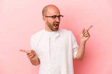 Pembe arka planda izole edilmiş beyaz kel bir adam farklı fotokopi alanlarını gösteriyor, birini seçiyor, parmaklarıyla gösteriyor..