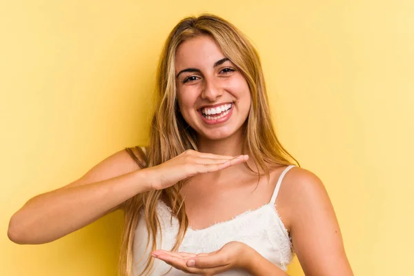 Young Caucasian Blonde Woman Isolated Yellow Background Holding Something Both — Stock Photo, Image