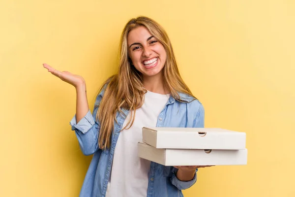 Mulher Loira Caucasiana Jovem Segurando Pizzas Isolado Fundo Amarelo Mostrando — Fotografia de Stock