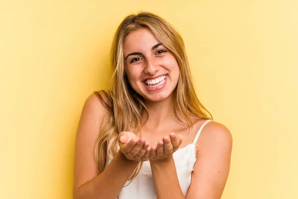 Junge Kaukasische Blonde Frau Isoliert Auf Gelbem Hintergrund Hält Etwas — Stockfoto