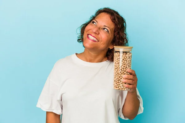 Middle Age Latin Woman Holding Chickpeas Jar Isolated Blue Background — Fotografia de Stock