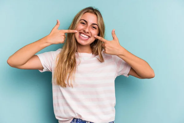 Joven Mujer Rubia Caucásica Aislada Sobre Fondo Azul Sonríe Señalando — Foto de Stock