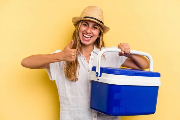 Sarı Arka Planda Izole Edilmiş Buzdolabı Tutan Beyaz Kadın Gülümsüyor — Stok fotoğraf