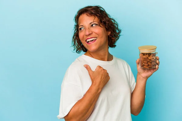 Young Mixed Race Woman Holding Almond Jar Isolated Blue Background — Fotografia de Stock