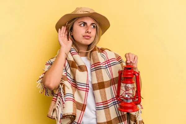 Ung Kaukasiska Innehav Lykta Isolerad Gul Bakgrund Försöker Lyssna Ett — Stockfoto