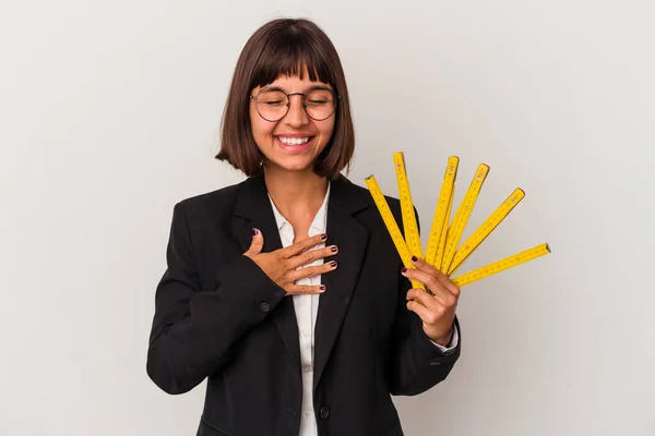 白い背景に隔離された測定テープを持っている若い混合レースビジネス女性は大声で手を胸に保つことを笑う — ストック写真