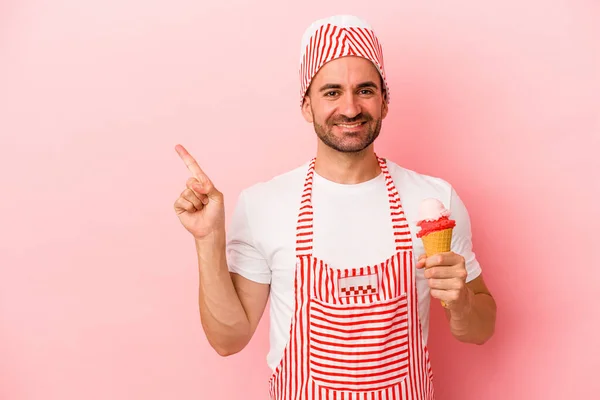 Jonge Ijsmaker Man Met Ijs Geïsoleerd Roze Achtergrond Glimlachend Wijzend — Stockfoto