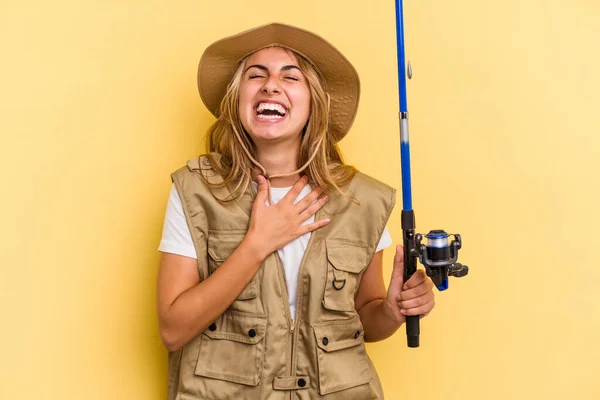 Young Caucasian Blonde Fisherwoman Holding Rod Isolated Yellow Background Laughs — Stock Photo, Image