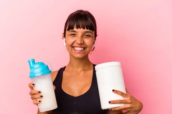 ピンクの背景に隔離されたタンパク質シェイクを飲む若い混合人種の女性 — ストック写真