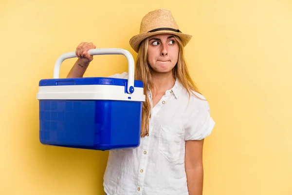 Mujer Joven Caucásica Sosteniendo Refrigerador Aislado Sobre Fondo Amarillo Confundido —  Fotos de Stock
