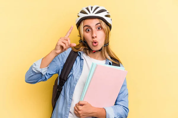 黄色の背景に隔離された自転車のヘルメットを身に着けている若い白人学生の女性アイデア インスピレーションの概念を持っている — ストック写真