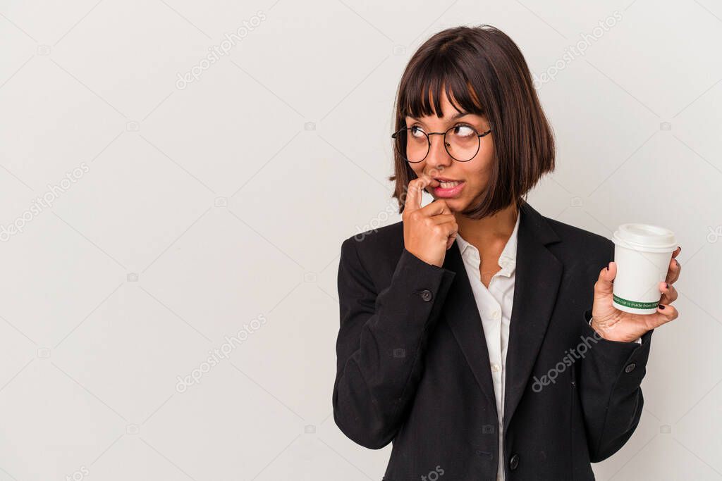 Young mixed race business woman holding a coffee isolated on white background relaxed thinking about something looking at a copy space.