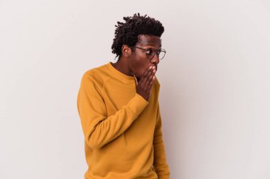 Genç Afro-Amerikalı bir adam beyaz arka planda izole edilmiş, gördüğü bir şey yüzünden şoka uğruyor..