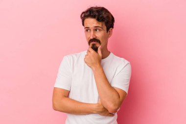 Pembe arka planda izole edilmiş genç beyaz adam virüs veya enfeksiyon yüzünden boğazında ağrı hissediyor..