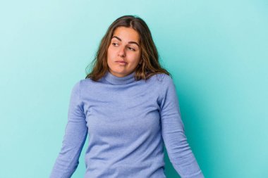 Mavi arka planda soyutlanmış beyaz bir kadın omuzlarını silker ve gözleri açık kalır..