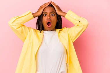 Genç Afrikalı Amerikalı kadın pembe arka planda izole edilmiş şaşırmış ve şok olmuş..