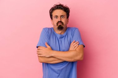 Pembe arka planda izole edilmiş genç beyaz adamın yanakları şişer, yorgun bir ifadesi vardır. Yüz ifadesi kavramı.