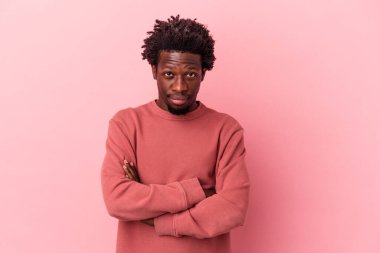 Genç Afrikalı Amerikalı adam pembe arka planda izole edilmiş şüpheli, belirsiz, seni muayene ediyor..