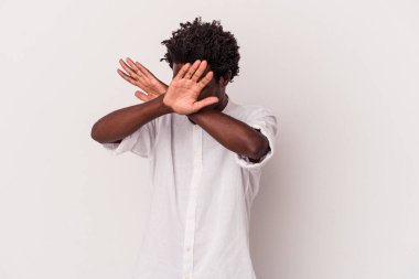 Genç Afrikalı Amerikalı adam beyaz arka planda izole edilmiş iki kolu çapraz tutuyor, inkar kavramı.