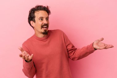 Pembe arka planda izole edilmiş genç beyaz bir adam neşeli bir şekilde gülüyor. Mutluluk kavramı.