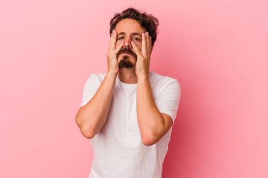 Pembe arka planda yalnız kalmış, ağlayan ve sızlanan genç beyaz bir adam..