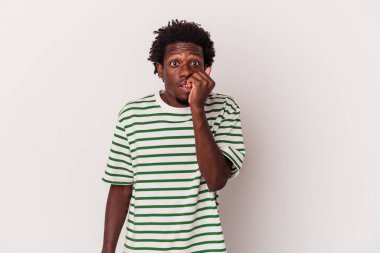 Genç Afrikalı Amerikalı bir adam beyaz arka planda izole edilmiş tırnak yiyor, gergin ve endişeli..