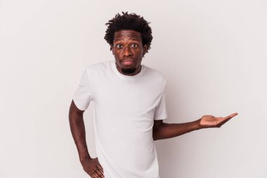 Beyaz arka planda izole edilmiş genç Afro-Amerikalı bir adam bir avuç içinde fotokopi alanı gösteriyor ve belinde başka bir el tutuyor..