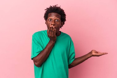 Pembe arka planda izole edilmiş genç Afro-Amerikan bir adam..